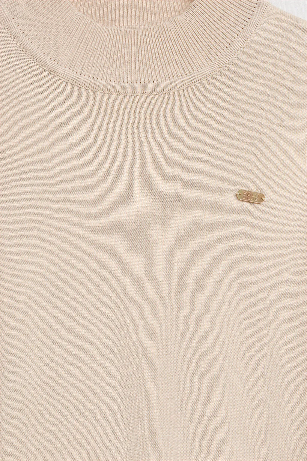 Jersey de punto beige con cuello elevado y detalle de botón nacarado PC